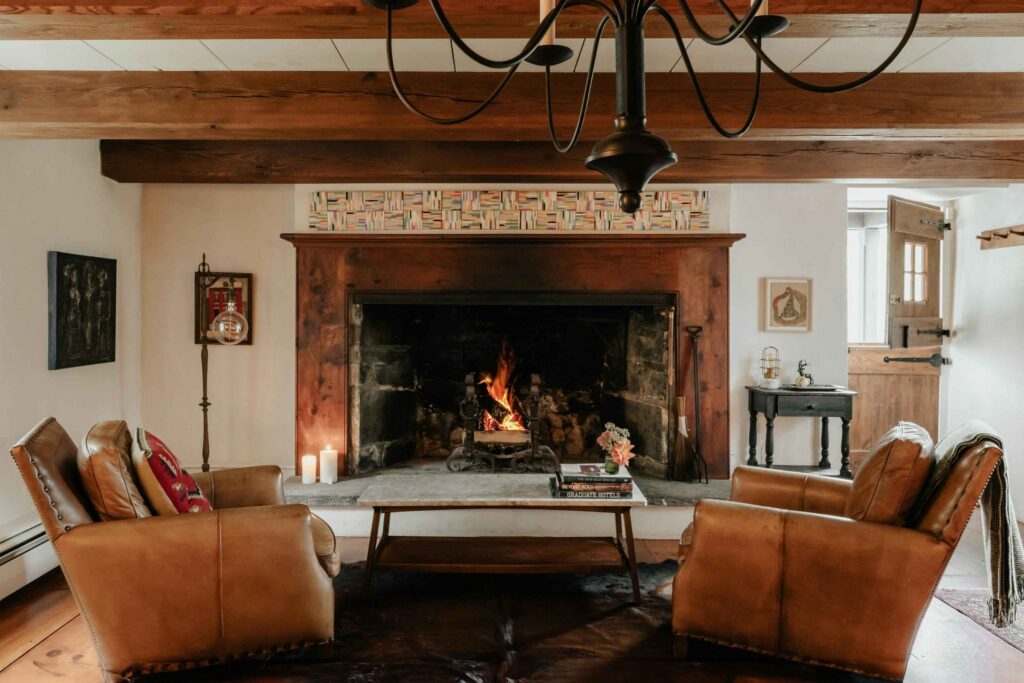 Warm living room blending farmhouse wood beams, Western leather accents, and coastal linen textures
